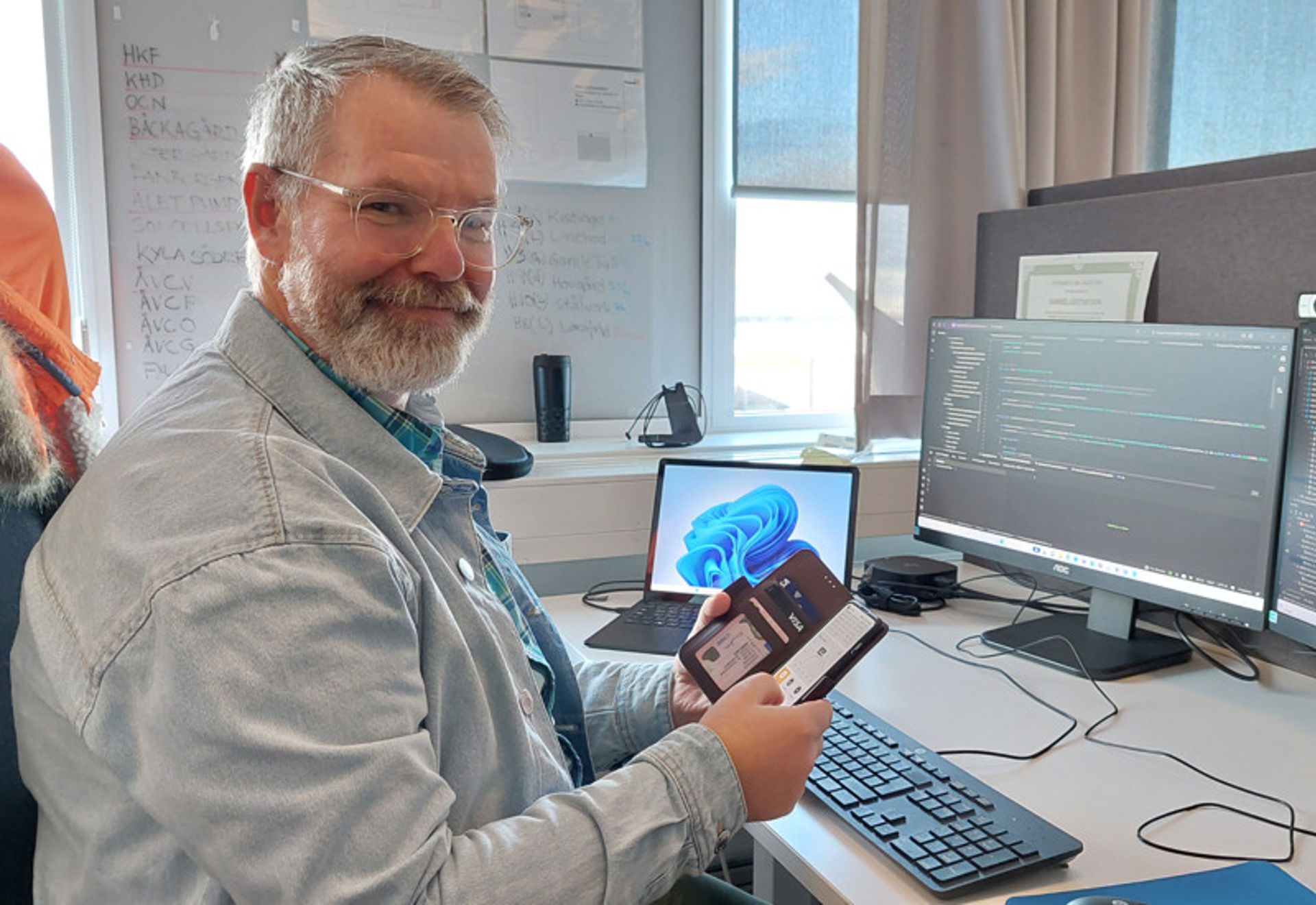 Daniel Gustafsson, lösningsarkitekt på HEM, med en telefon 